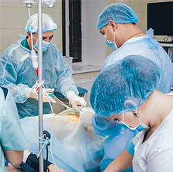 surgeons in operating room using bair hugger on patient