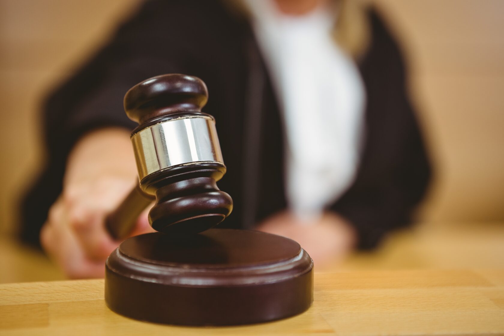 Image of a gavel coming down in a courtroom.